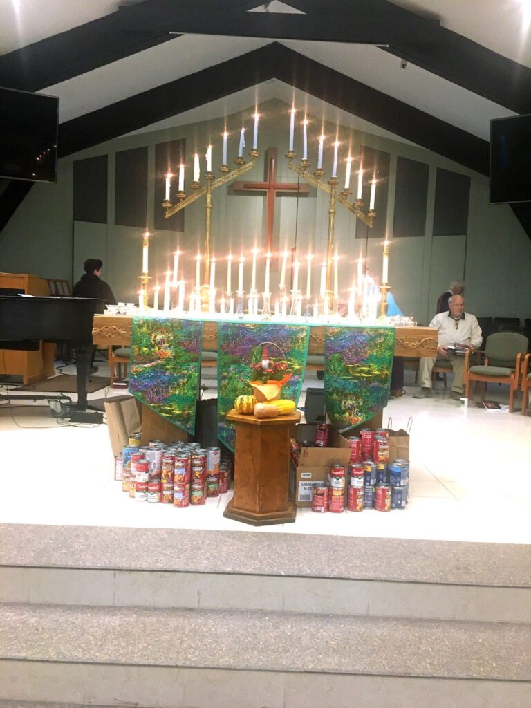 Church altar with donated food and lit candles