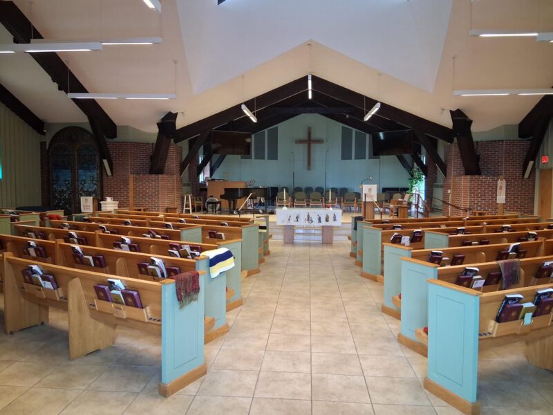 Church sanctuary facing cross with altar and pews