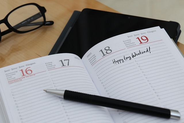 desktop calendar with a pen and the words "happy weekend"
